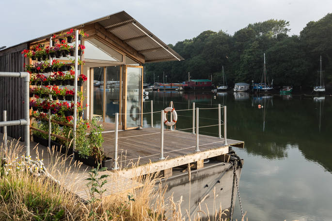 The growing wall and flowers on the outdoor deck of Amelie with the living space doors open letting the sea breeze fill the eco barge 