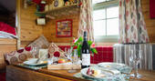 Delicious cheese and wine laid out on the table inside Fairfield shepherd's hut at Acorn Farm in Devon