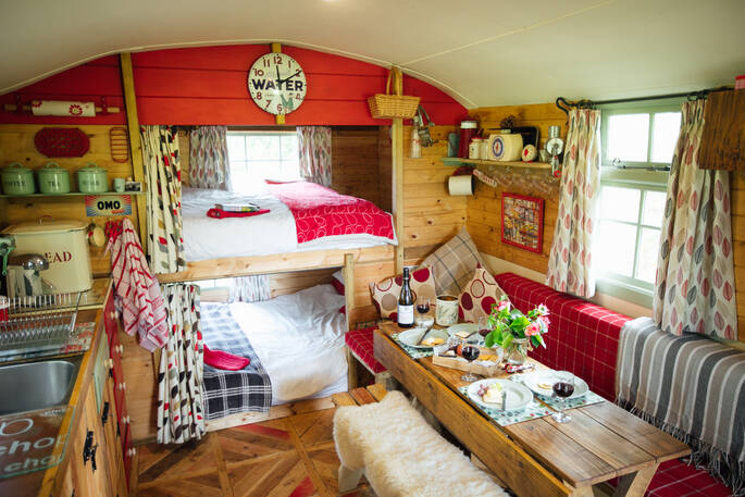 Two built in double bunk beds and bench inside of Fairfield at Acorn Farm in Devon