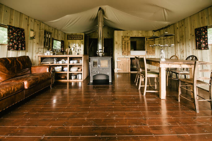 Berridon Farm safari tent interior with cosy log burner and comfortable sofa