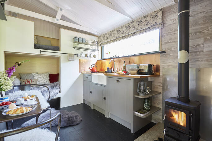 The woodburner roars in the cabin's fitted kitchen next to the cabin style kids bunk beds