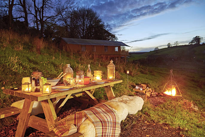 Dine al fresco around the safari tent's picnic table under open skies with a campfire feast