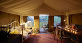 From out from interior of Tamar safari tent of deck and rolling hills at Brownscombe at dusks