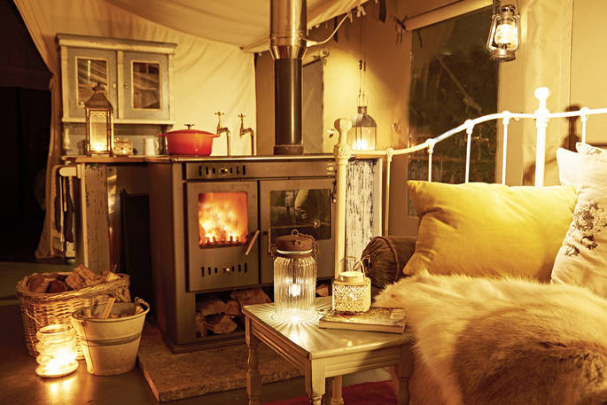 Settle in the evening with the woodburner roaring, a casserole of the stove and candles illuminating your safari tent for six