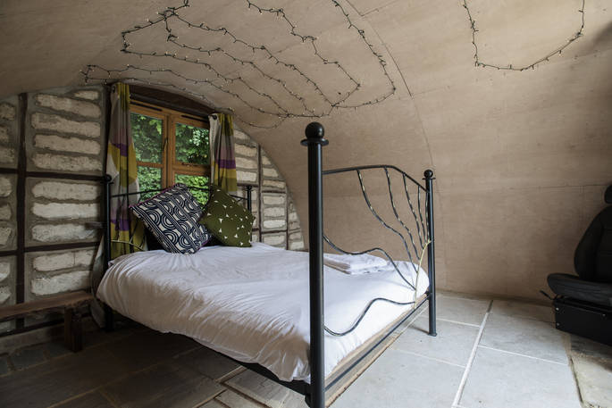 The king-size bed and interior of the hobbit hut at The Secret Garden camp at Guilden Gate in Hertfordshire