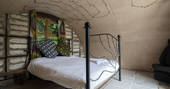 The king-size bed and interior of the hobbit hut at The Secret Garden camp at Guilden Gate in Hertfordshire
