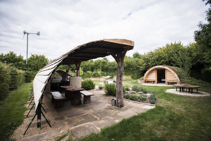 The Secret Garden camp with hobbit hut, covered outdoor kitchen and dining area, hammock swing and wood-fired hot tub