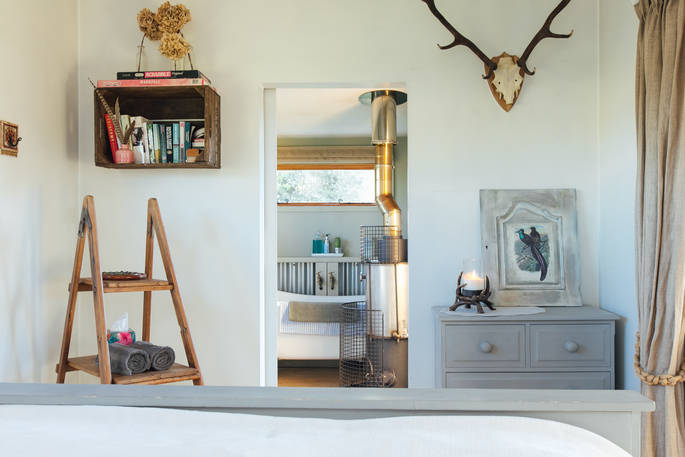 The gorgeous white washed bedroom at the Woodcock Cabin, Bagthorpe Farm in Norfolk