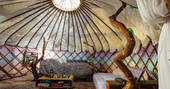 An inside view of Jericho Yurt with a warm bed and crafty wood structure.