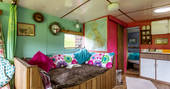 Splashes of colour in the interior living space of Van Goff cabin with sofa bed, kitchen and private bathroom